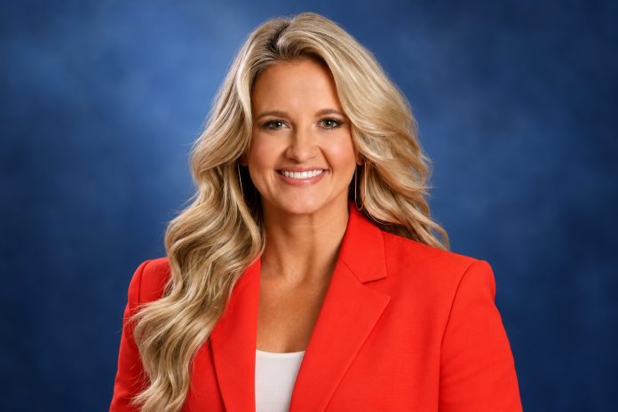 Editorial portrait of Kelsey Riggs against a blue studio-style background.